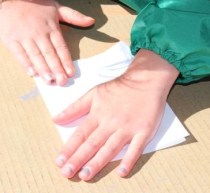 Squishing the folded paper together to spread and mix the paint.