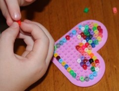 A placing beads on her peg board.