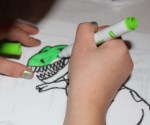L colouring her dinosaur.