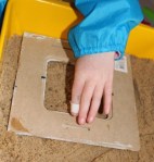 Pressing the gluey frame into the sand.