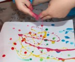 Drizzling paint onto paper.