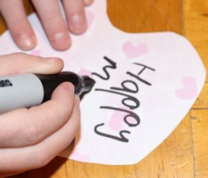 Writing a message on the back of the hand-print.